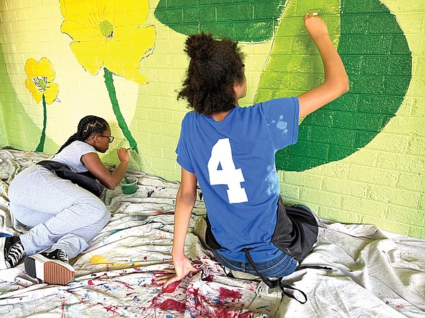 Students at Martin Luther King Jr. Middle School work on a nature-themed mural in Jefferson Park.