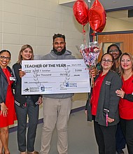 Highpoint School Teacher Aurick Smither, holding check, poses with the HCDE Special Schools Division after they surprised him with the news of his selection as the Department’s 2023-2024 Teacher of the Year.