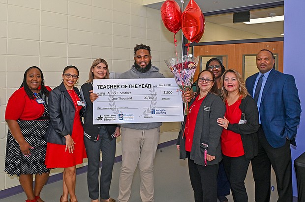 Highpoint School Teacher Aurick Smither, holding check, poses with the HCDE Special Schools Division after they surprised him with the news of his selection as the Department’s 2023-2024 Teacher of the Year.