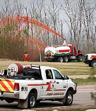 A pumper truck sprays fire retardant on trees around the evacuated neighborhood of Beacon Hill in Fort McMurray, Alberta, Canada, on May 15.
Mandatory Credit:	Jeff McIntosh/The Canadian Press/AP via CNN Newsource