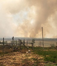 Smoke rises as fire singes Fort Nelson on May 14.
Mandatory Credit:	Cheyenne Berreault/Anadolu/Getty Images via CNN Newsource