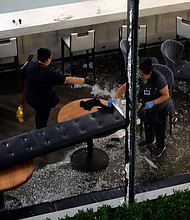 Workers clean up broken glass inside a damaged downtown restaurant after a severe thunderstorm Thursday in Houston.
Mandatory Credit:	David J. Phillip/AP via CNN Newsource