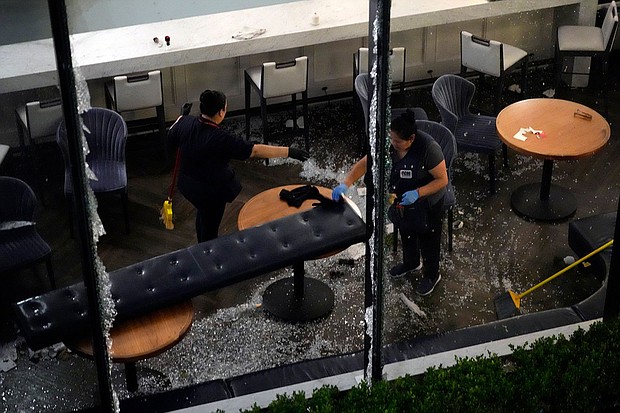 Workers clean up broken glass inside a damaged downtown restaurant after a severe thunderstorm Thursday in Houston.
Mandatory Credit:	David J. Phillip/AP via CNN Newsource
