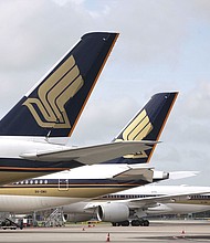 Singapore Airlines planes on the tarmac are seen here in December 2020.
Mandatory Credit:	Kevin Lim/AP via CNN Newsource
