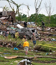Residents and first responders survey the remains of tornado-ravaged homes in Greenfield, Iowa, on Tuesday.
Mandatory Credit:	Charlie Neibergall/AP via CNN Newsource