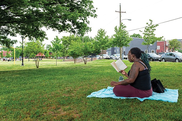 Tonika Shackleford of Jackson Ward takes advantage of spring temperatures to read Iyanla Vanzant’s “Meantime: Finding Yourself and the Love You Want.”