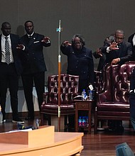 People stretch out their hands as they pray for Dr. Marcus Crosby, right, during a community celebration in honor of Rev. William “Bill” Lawson at Wheeler Avenue Baptist Church on Thursday, May 23, 2024, in Houston. Brett Coomer/Staff photographer)