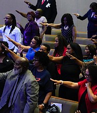 People stretch out their hands as they pray for Dr. Marcus Crosby during a community celebration in honor of Rev. William “Bill” Lawson at Wheeler Avenue Baptist Church on Thursday, May 23, 2024, in Houston. Brett Coomer/Staff photographer)