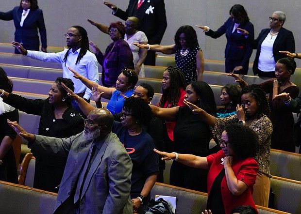 People stretch out their hands as they pray for Dr. Marcus Crosby during a community celebration in honor of Rev. William “Bill” Lawson at Wheeler Avenue Baptist Church on Thursday, May 23, 2024, in Houston. Brett Coomer/Staff photographer)