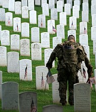A US Army Old Guard soldier places a flag at a headstone during the annual 'Flags In' event ahead of Memorial Day at Arlington National Cemetery in Arlington, Virginia, on May 23.
Mandatory Credit:	Kevin Lamarque/Reuters via CNN Newsource