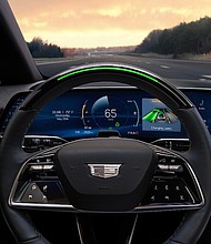 View of the 2025 Cadillac OPTIQ steering wheel with standard Super Cruise and steering wheel light bar activated.