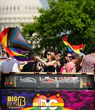 Parade participants wave from the top of a double decker tour bus as Capital Pride Parade makes its way down Pennsylvania Ave. NW on June 8.
Mandatory Credit:	Bill Clark/CQ-Roll Call, Inc./Getty Images via CNN Newsource