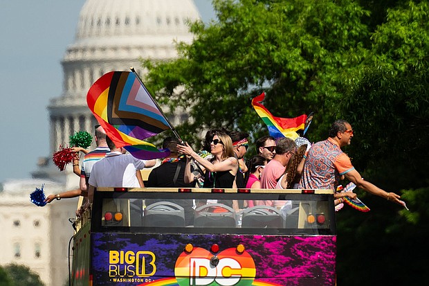 Parade participants wave from the top of a double decker tour bus as Capital Pride Parade makes its way down Pennsylvania Ave. NW on June 8.
Mandatory Credit:	Bill Clark/CQ-Roll Call, Inc./Getty Images via CNN Newsource