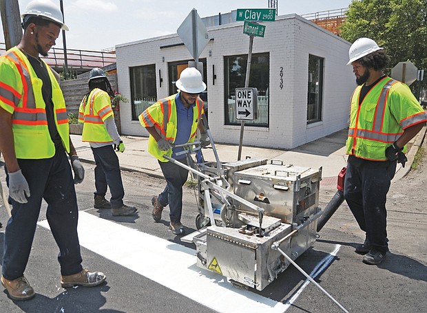 Department of Public Works’ crew chief, Anthony Jones, 35, creates a crosswalk in Scott’s Addition on Monday, June 17. It’s important for Jones and others who work outside to stay hydrated this week as temperatures soar into the 90s.