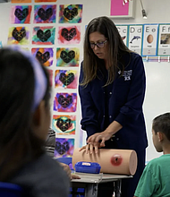 Kate Carleton, center, teaches children at a California elementary school how to stop a wound from bleeding out. CNN