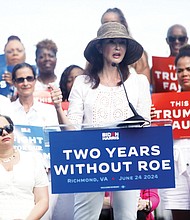 Actress and activist Ashley Judd addresses a crowd in Church Hill on the second anniversary of the overturning of federal abortion protections. U.S. Rep. Jennifer McClellan (D-Va.), seated left, listens along with state Sen. L. Louise Lucas (D-Portsmouth).