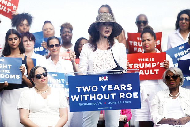 Actress and activist Ashley Judd addresses a crowd in Church Hill on the second anniversary of the overturning of federal abortion protections. U.S. Rep. Jennifer McClellan (D-Va.), seated left, listens along with state Sen. L. Louise Lucas (D-Portsmouth).
