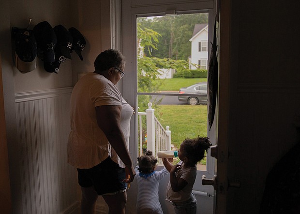 Vicki Lightfoot stands by the front door with Maurice and Marie while waiting for the other grandchildren, Alysha and Corey, to finish getting ready for school.
