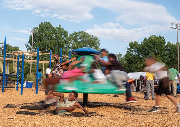 Children enjoy a rotating play structure at Broad Rock Sports Complex in South Side last week. A large crowd gathers nearby for the People’s Evolution Music Festival, a free event organized by Councilmember Nicole Jones. The festival offered live music performances, along with food and vendor stalls.