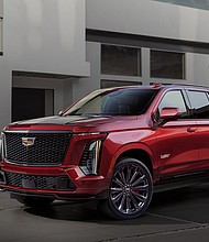 Front ¾ view of the 2025 Cadillac Escalade-V, with a house in the background.