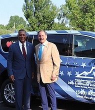 Virginia Secretary of Veterans and Defense Affairs Craig Crenshaw, left, and DVS Commissioner Chuck Zingler standing with one of the donated vans.