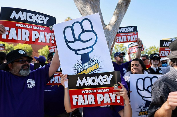 Workers gather with signs as the Teamsters union and Disney cast members demand fair wages at a rally outside Disneyland, in Anaheim, California, in July 17.
Mandatory Credit:	David Swanson/Reuters via CNN Newsource