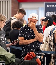 Passengers try to rebook their flight to Iowa at Hartsfield Jackson International Airport in Atlanta on Friday amid the major tech outage.
Mandatory Credit:	Ben Gray/AP via CNN Newsource