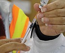 A nurse prepares vaccines during a mass vaccination event held at the Richmond Raceway in 2021.