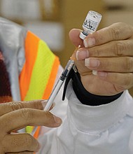 A nurse prepares vaccines during a mass vaccination event held at the Richmond Raceway in 2021.