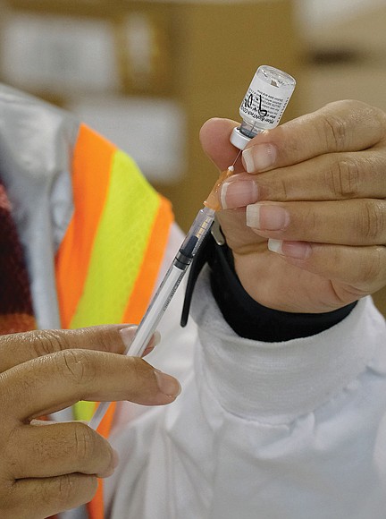 A nurse prepares vaccines during a mass vaccination event held at the Richmond Raceway in 2021.