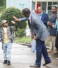 Mayor Levar M. Stoney, right, gives a high five to a Woodville Elementary School student as they arrive on their first day back at school on Monday, July 22. The school is part of the RPS200 pilot program that was launched last year.