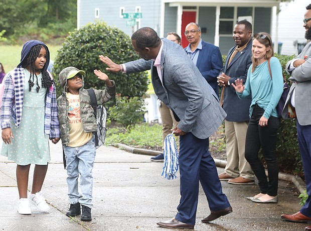 Mayor Levar M. Stoney, right, gives a high five to a Woodville Elementary School student as they arrive on their first day back at school on Monday, July 22. The school is part of the RPS200 pilot program that was launched last year.