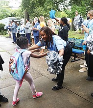 Woodville Elementary School Assistant Principal Nsombi Morrison, right, hugs and cheers for students on their first day back at school Monday, July 22, as a part of the RPS200 program.