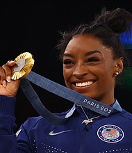 Gold medalist Simone Biles of United States celebrates on the podium.
Mandatory Credit:	Hannah McKay/Reuters via CNN Newsource