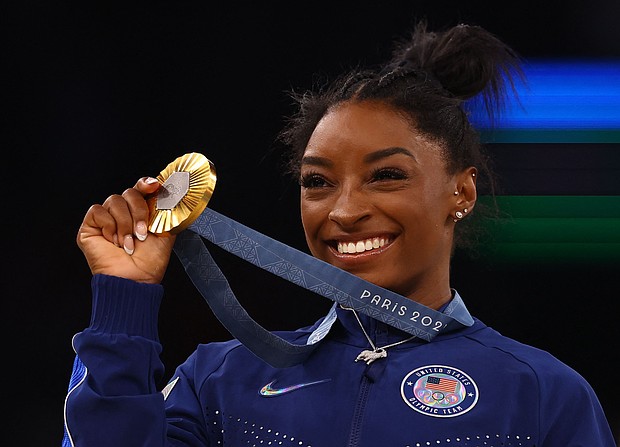 Gold medalist Simone Biles of United States celebrates on the podium.
Mandatory Credit:	Hannah McKay/Reuters via CNN Newsource