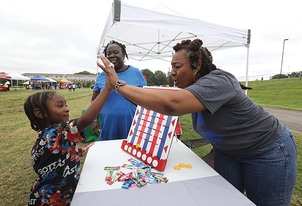 Edward Butler III, left, shows his enthusiasm with Salena Scott, right, a teacher at Martin Luther King Jr. Middle School, as Nicole Sparkman, a teacher at Armstrong High School looks on.