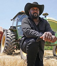 Farmer John Boyd Jr., poses for a portrait in 2021 during a break from baling hay at his farm in Boydton, Va.
