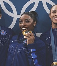From left to right, Suni Lee, Simone Biles and Hezly Rivera celebrate July 30 after winning the gold medal during the women’s artistic gymnastics team finals round at Bercy Arena at the 2024 Summer Olympics, in Paris.
