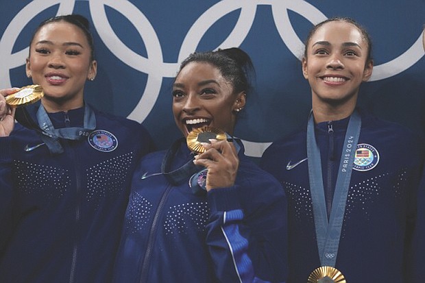From left to right, Suni Lee, Simone Biles and Hezly Rivera celebrate July 30 after winning the gold medal during the women’s artistic gymnastics team finals round at Bercy Arena at the 2024 Summer Olympics, in Paris.