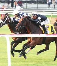 Jockey Jose Ortiz rides thoroughbred Moira to a close victory over Fev Rover and jockey Javier Castellano during the Beverly D race at Colonial Downs’ Festival of Racing on Aug. 11.