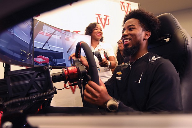Rajah Caruth, a NASCAR Craftsman Truck Series driver, test drives the driving simulator donated by himself and Microsoft to Virginia Union University.