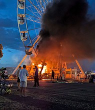 Images showed the Ferris wheel on fire with smoke billowing from the ride.
Mandatory Credit:	Picture Alliance/DPA/AP via CNN Newsource