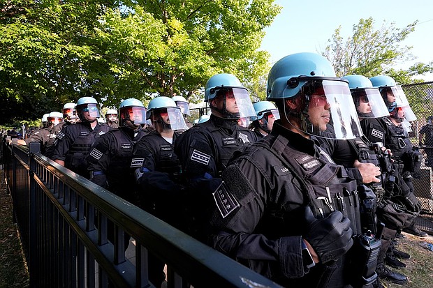 Police line up after a piece of fence was knocked down by protesters surrounding the United Center at the Democratic National Convention Monday, Aug. 19, 2024, in Chicago.
Mandatory Credit:	Alex Brandon/AP via CNN Newsource