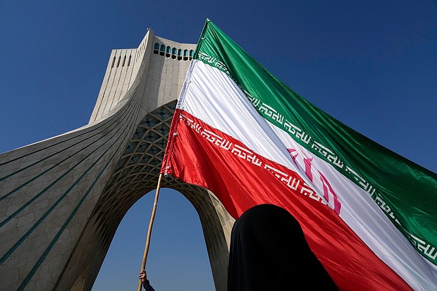 An Iranian flag is carried under the Azadi (Freedom) monument tower during the annual rally commemorating Iran's 1979 Islamic Revolution in Tehran in February.
Mandatory Credit:	Vahid Salemi/AP/File via CNN Newsource