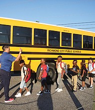 G.H. Reid Elementary School students proceed to the front door of the school building on the first day of school Monday, Aug. 19.