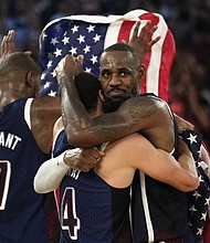 Stephen Curry, center, hugs LeBron James, right, after the United States won a men’s gold medal basketball game at the 2024 Summer Olympics in Paris.