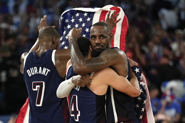 Stephen Curry, center, hugs LeBron James, right, after the United States won a men’s gold medal basketball game at the 2024 Summer Olympics in Paris.