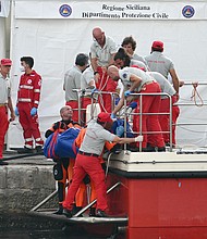 Rescuers carry a body after divers return in Porticello harbor in Sicily, Italy, August 22.
Mandatory Credit:	Alberto Pizzoli/AFP/Getty Images via CNN Newsource