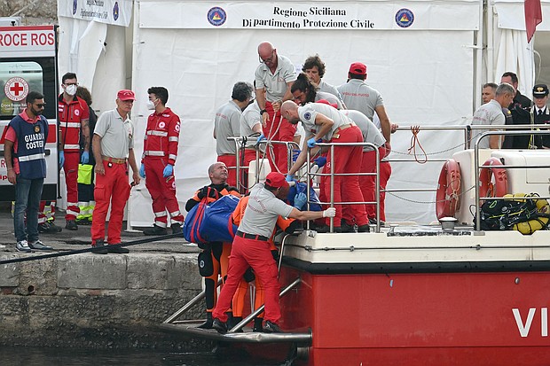 Rescuers carry a body after divers return in Porticello harbor in Sicily, Italy, August 22.
Mandatory Credit:	Alberto Pizzoli/AFP/Getty Images via CNN Newsource