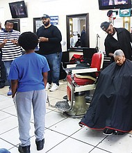 Henrico County Supervisor Tyrone Nelson speaks at Unlimited Barber Shop in Richmond about registering and voting for the Democratic presidential ticket of Harris and Walz.
Listening are Delegate Michael J. Jones, left, and state Sen. Lamont Bagby, who also shared their views during the Virginia Democrats’ “Barbershop Talk Tour.” Afterward, 10-year-old Nii-Armah Ayree boldly asked the first question about Vice President Kamala Harris’ plans if elected president.